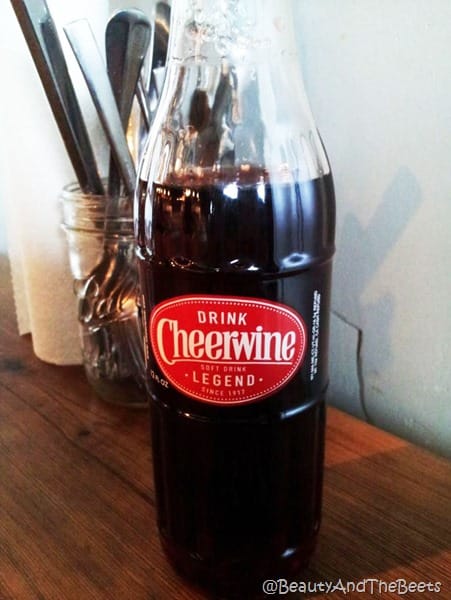 bottle of cheerwine and silverware behind the bottle
