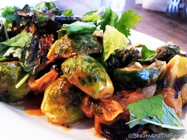 a plate of halvedd brussels sprouts with a curry sauce and green lettuce