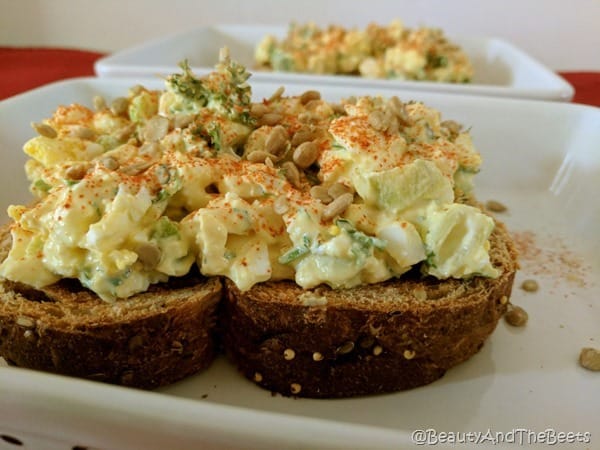 yellow egg salad with cayenne pepper on thick toast on a white dish