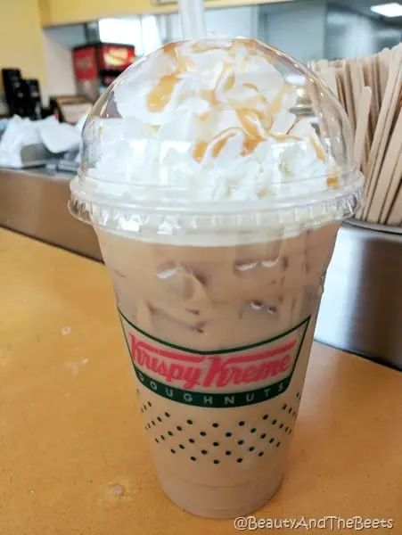 an iced coffee from Krispy Kreme topped with whipped cream and a caramel drizzle