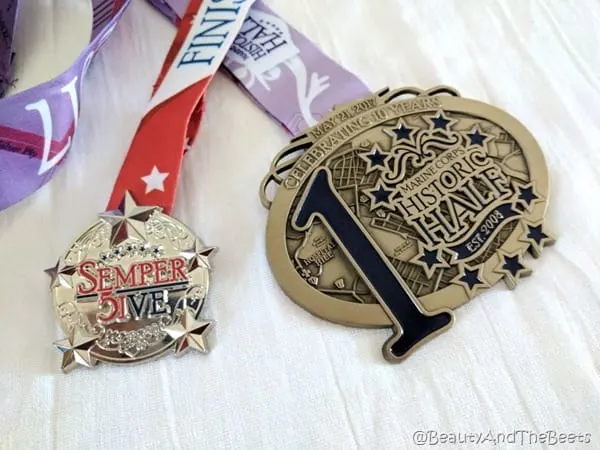 the Semper Five Miler medal and the much larger Historic Half medal on a white background
