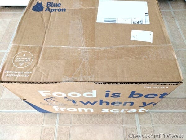 a large cardboard box from Blue Apron on a kitchen floor