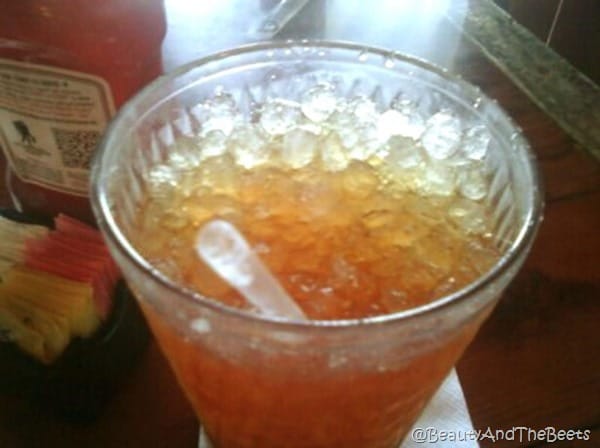 a cup of iced tea with crushed ice and a straw