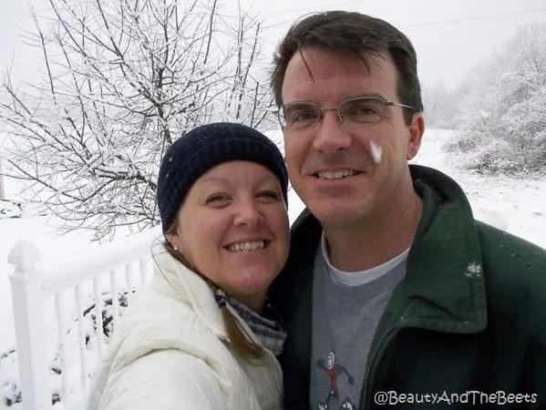 Anna and Mr Beet standing out in the snow with snow falling knit cap white jacket