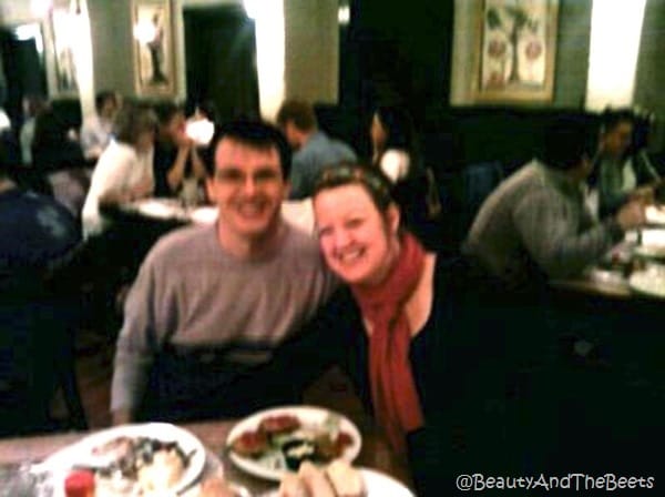 the author with a pink scarf next to Mr Beet at a table in a crowded restaurant