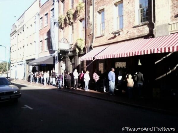 a line of people at LAdy and Sons a red brick building on a block of historic buildings