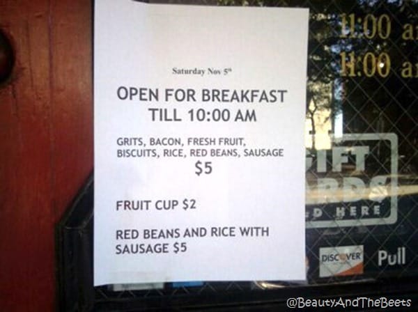 the glass and wodden front door of a restaurant with a white paper listing the breakfast men nu taped to the door