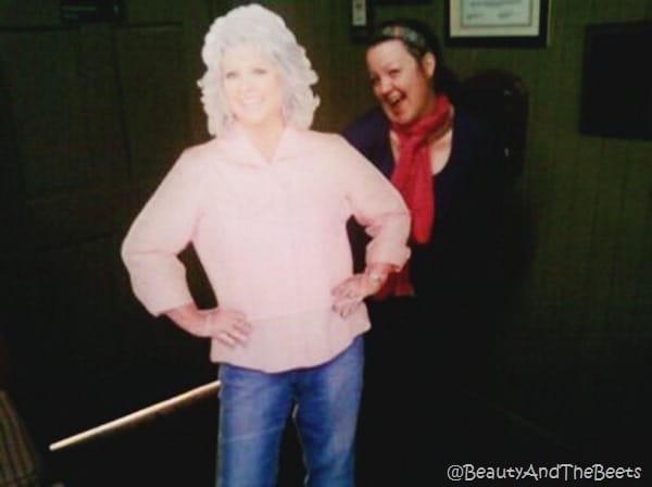 the author wearing a pink scarf next to a cutout of Paula Deen in a pink shirt