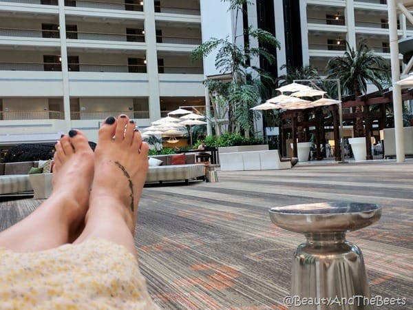 feet on an ottoman looking into the lobby of a hotel