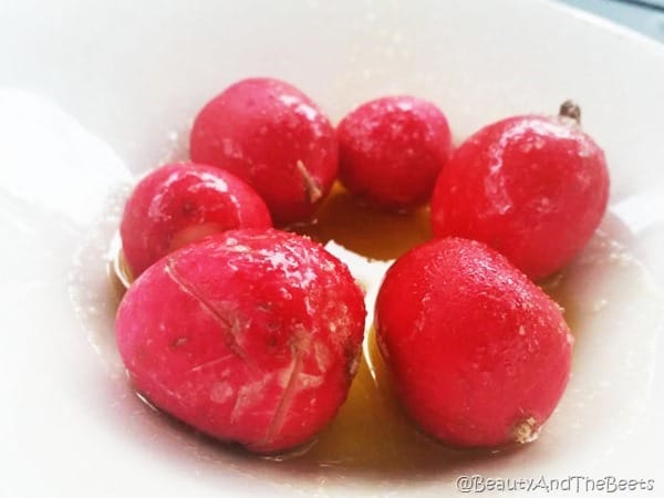 6 whole radish with olive oil drizzle and salt in a white bowl