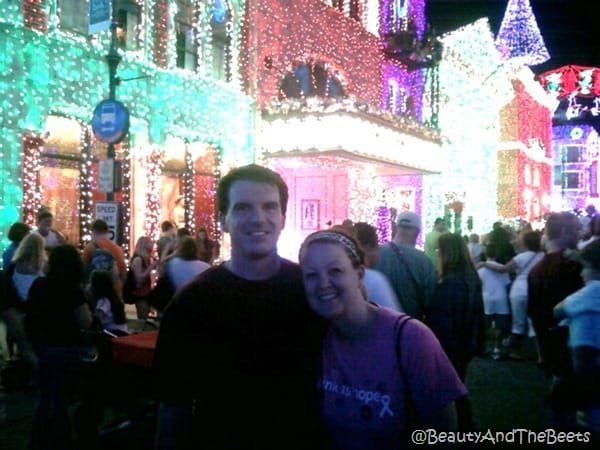 The author and Mr Beets pose in front of bright Christmas lights