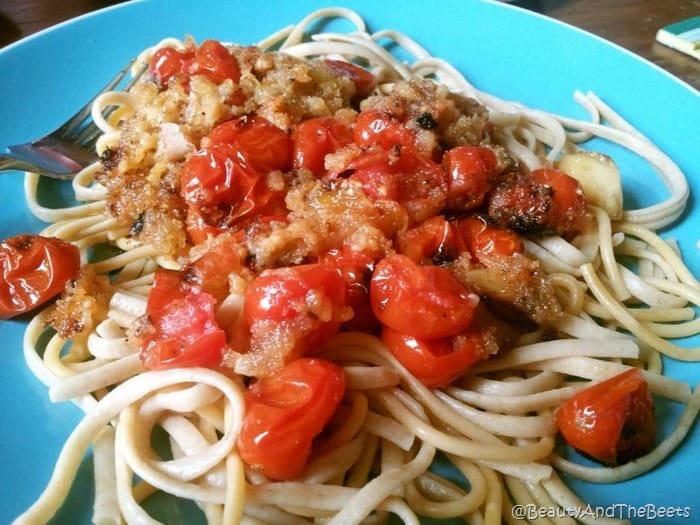 white linguine pasta topped with roasted tomatoes, garlic and breadcrumbs on a blue plate