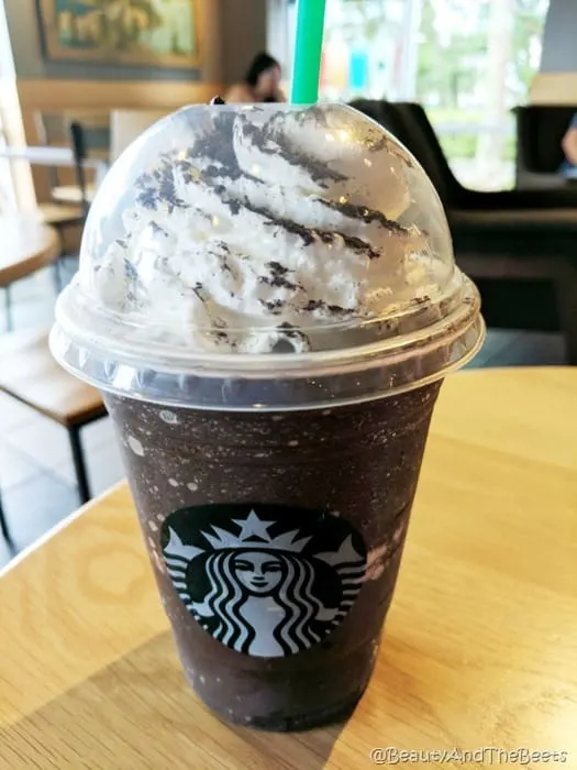 a dark chocolate frappuccino in a Starbucks cup on a light wooden table