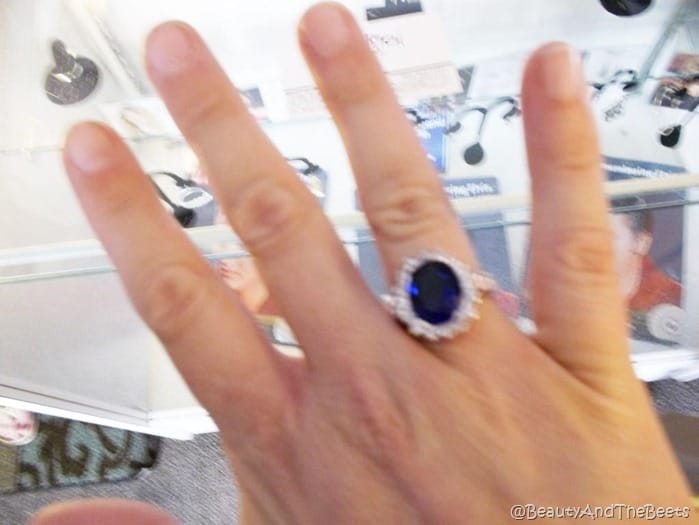 a picture of a hand with a blue diamond encrusted ring