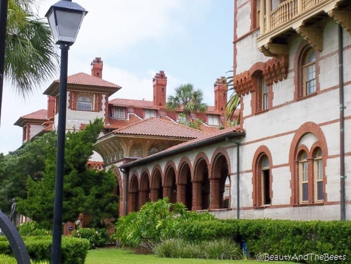 spanish tile roof and spanish architecture with arches and shrubery and a lamp post