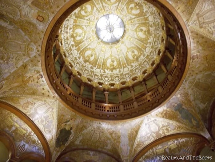 the camera looking up at a well ormanated gold dome 