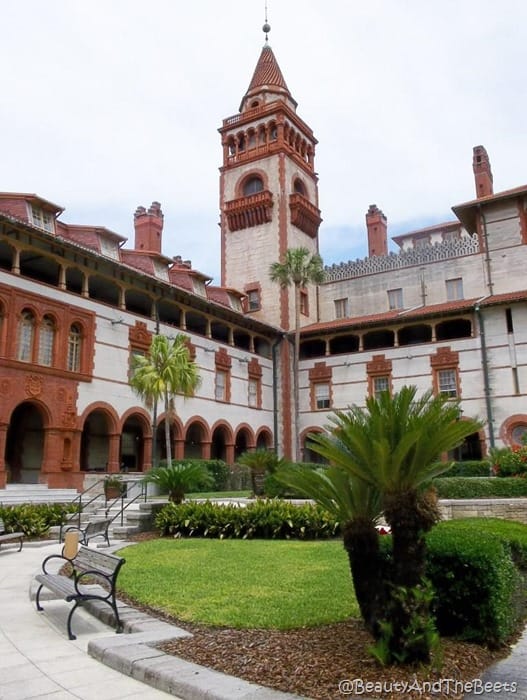 the tower of the ponce de leon hotel heavy spanish architecture with white and brown accents and palm trees