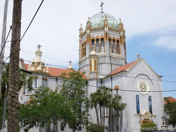 a church with gold features and a spanish tile roof with a giant domed tower