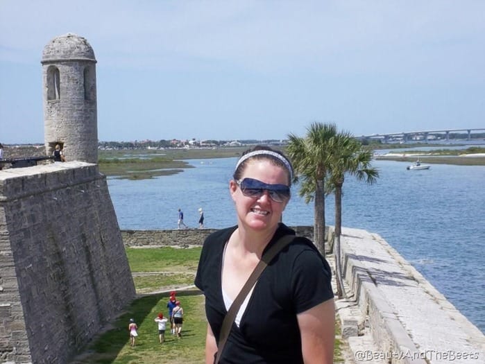 the author on the top of the spanish fort with a lookout tower to the left and the sea and palm trees in the background