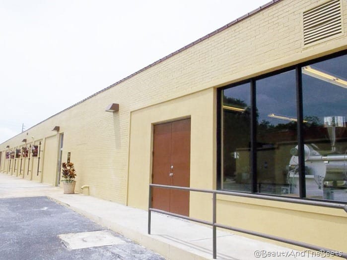 an exterior shot of a yellow brick one story building very plain with a door to the chocolate factory