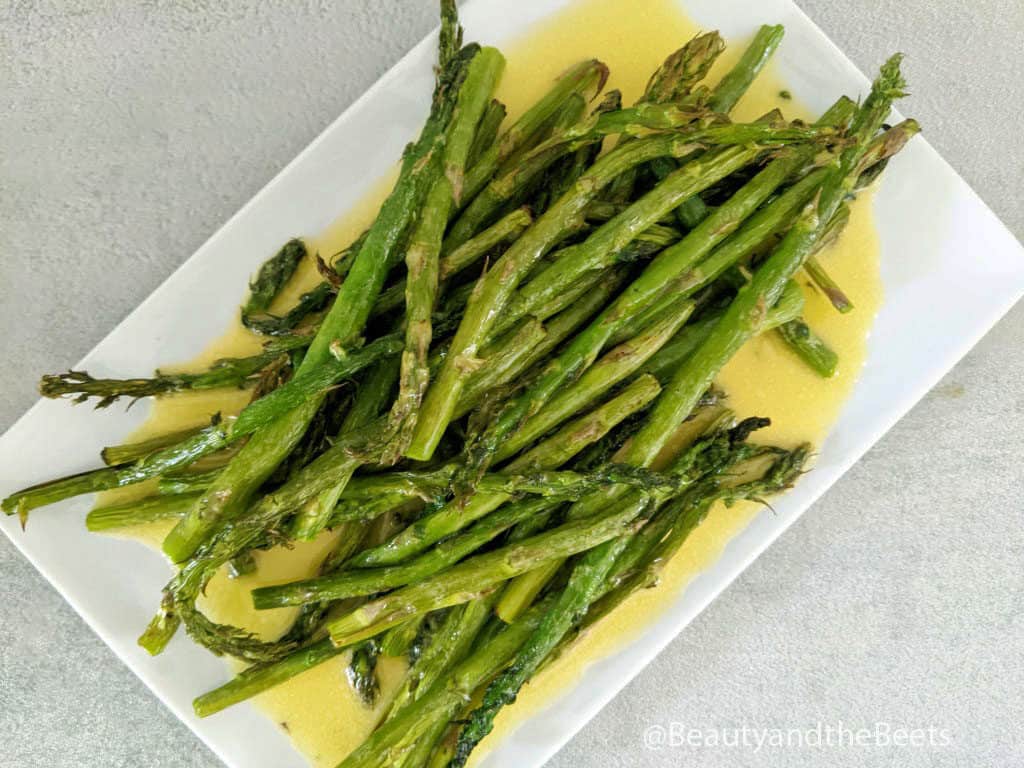 a rectangle white plate with air fryer asparagus spears and hollandaise sauce
